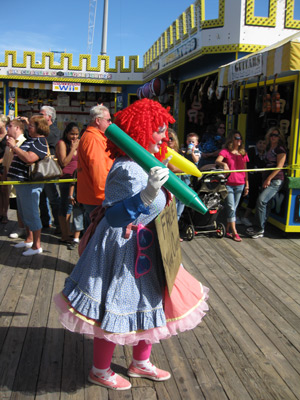 a single clown walking along the boardwalk